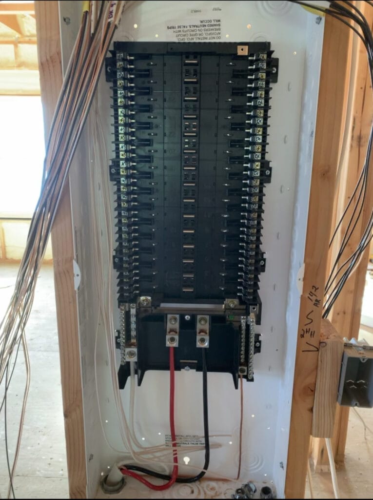 An open electrical panel with exposed wiring showing a vertical array of circuit breakers in East Lake FL